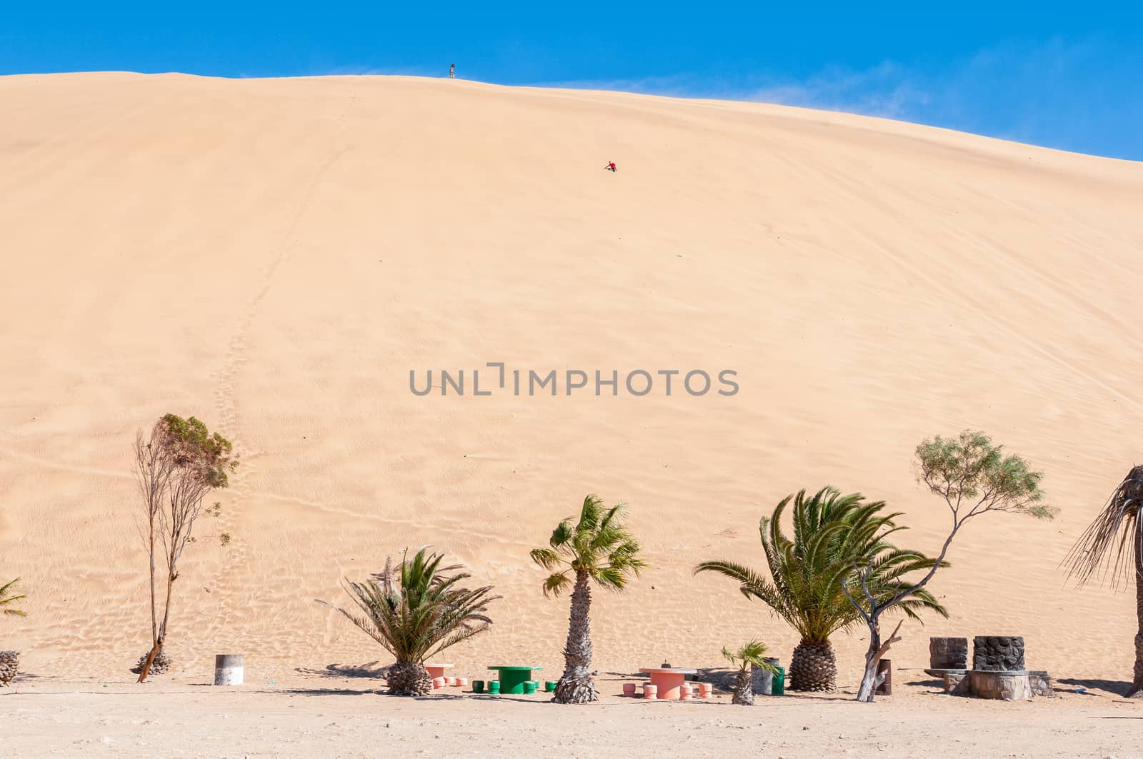 People are visible on Dune 7 at Walvis Bay on the Atlantic Ocean coast of Namibia
