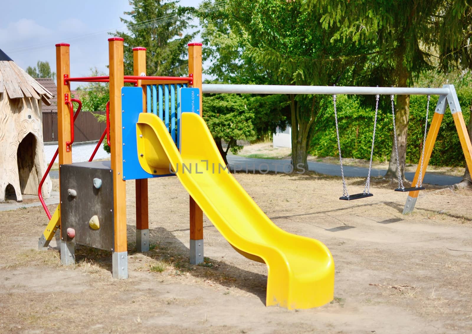 Yellow slide and chain swings in the empty playground.