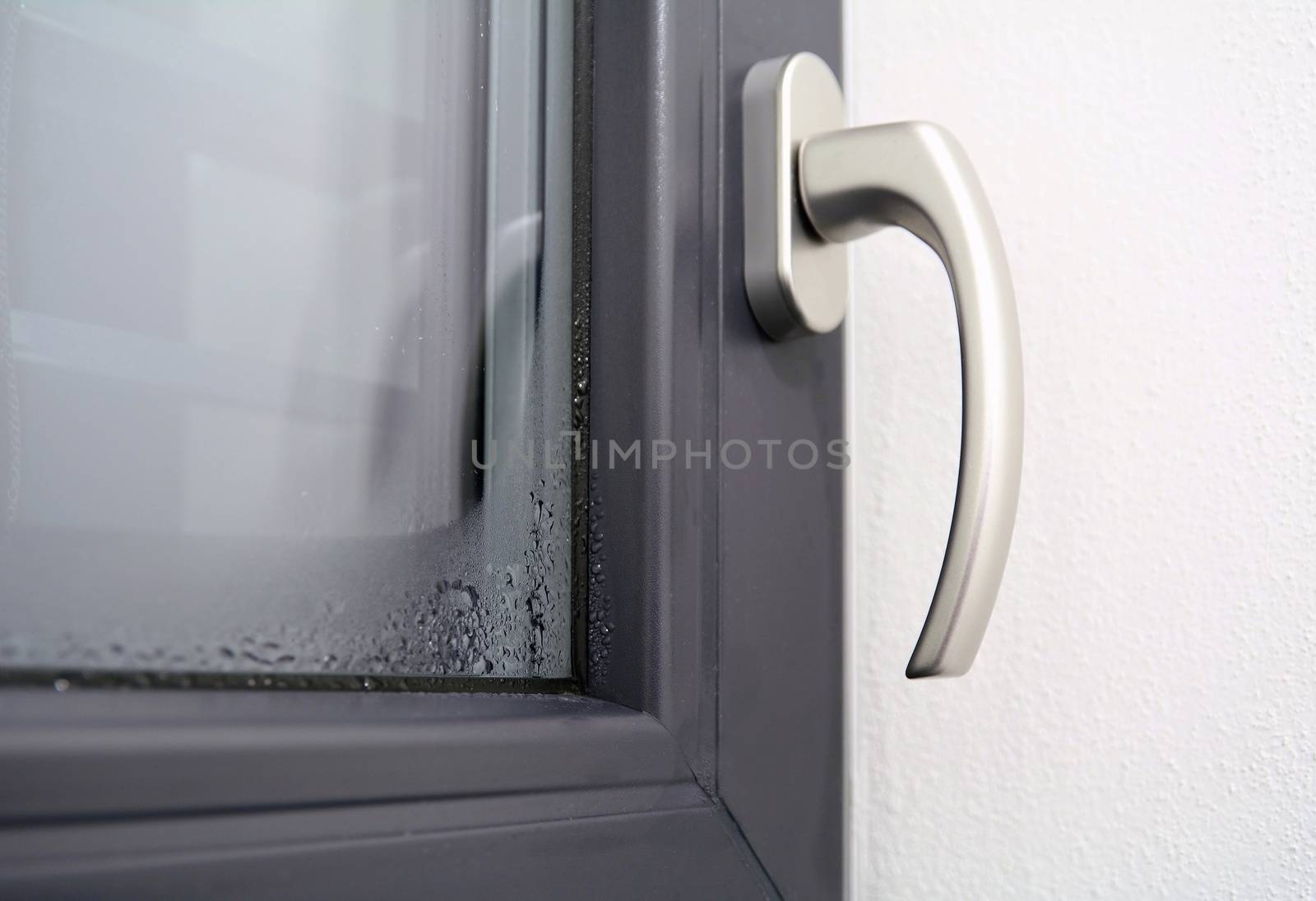 Closeup of the winter condensation on the inside of a window, insulation failure. A window glass covered with condensation drops.