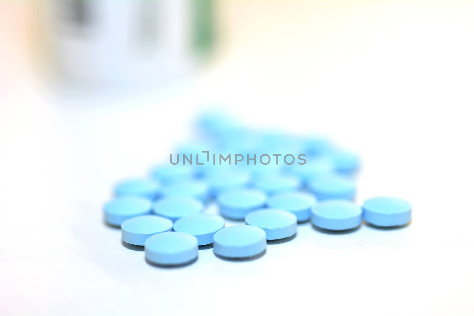 Closeup of a Blue Drug Pills Spilling Out of a Bottle on the White Background.