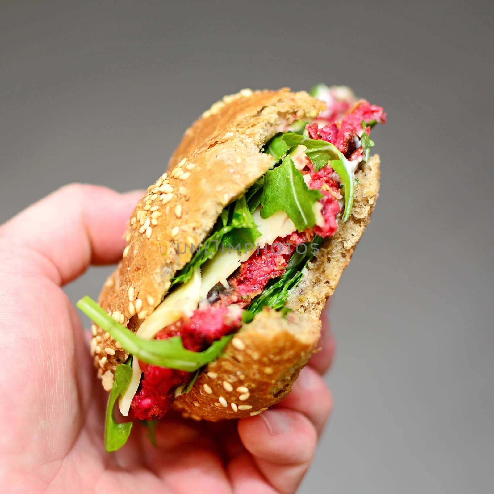 Hand Holding a Beetroot Burger with Arugula by hamik