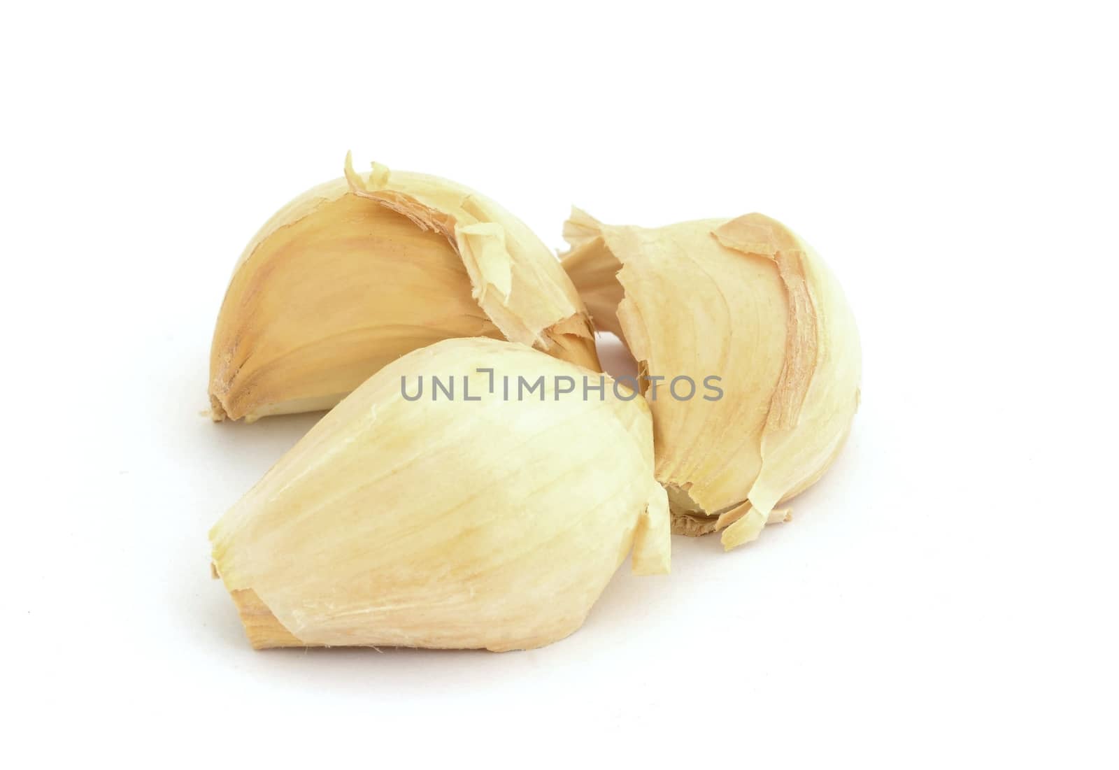 Three cloves of garlic on white background.