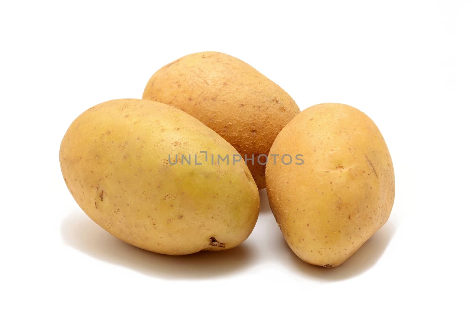 Three whole fresh potatoes on white background.