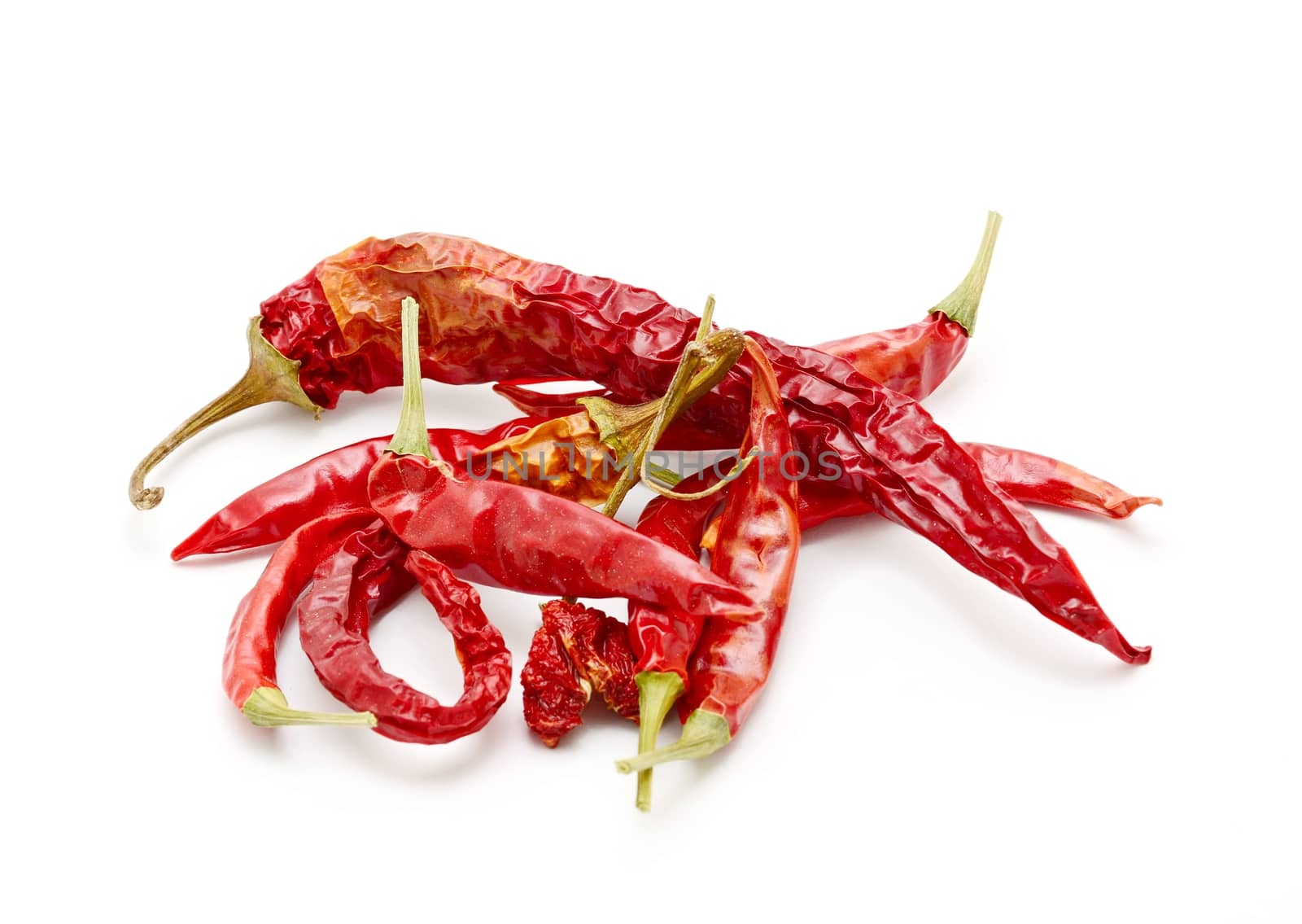 Heap of dried red hot chilli peppers on white background.