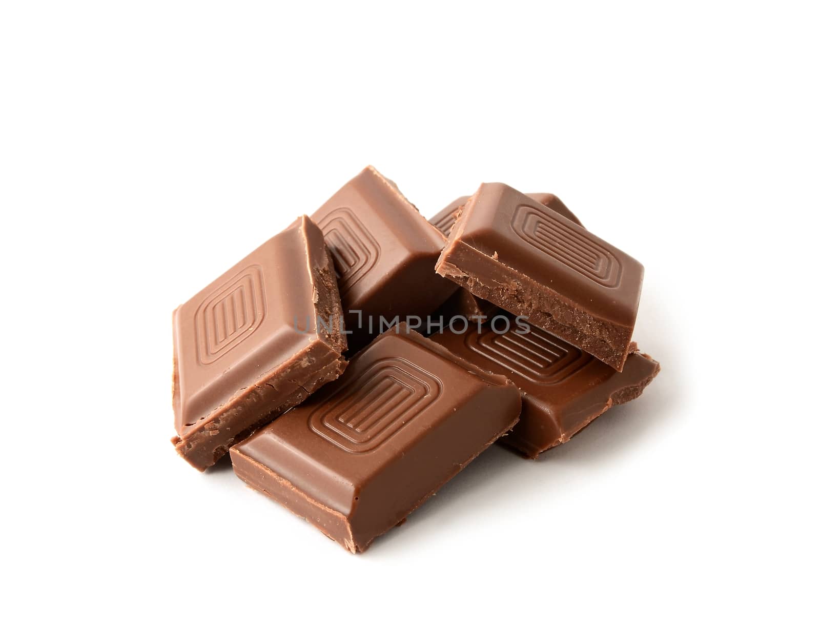 Heap of chocolate pieces over white background.