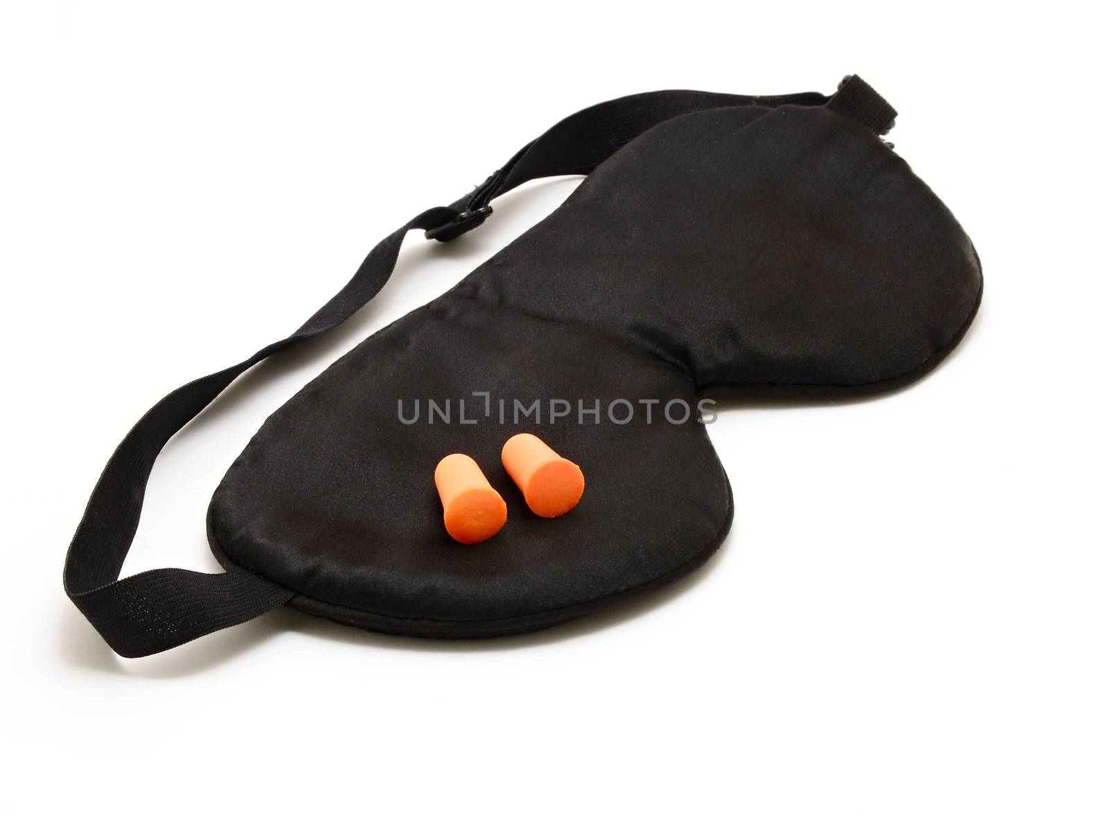 Black sleep eye mask with pair of orange foam ear plugs over white background.