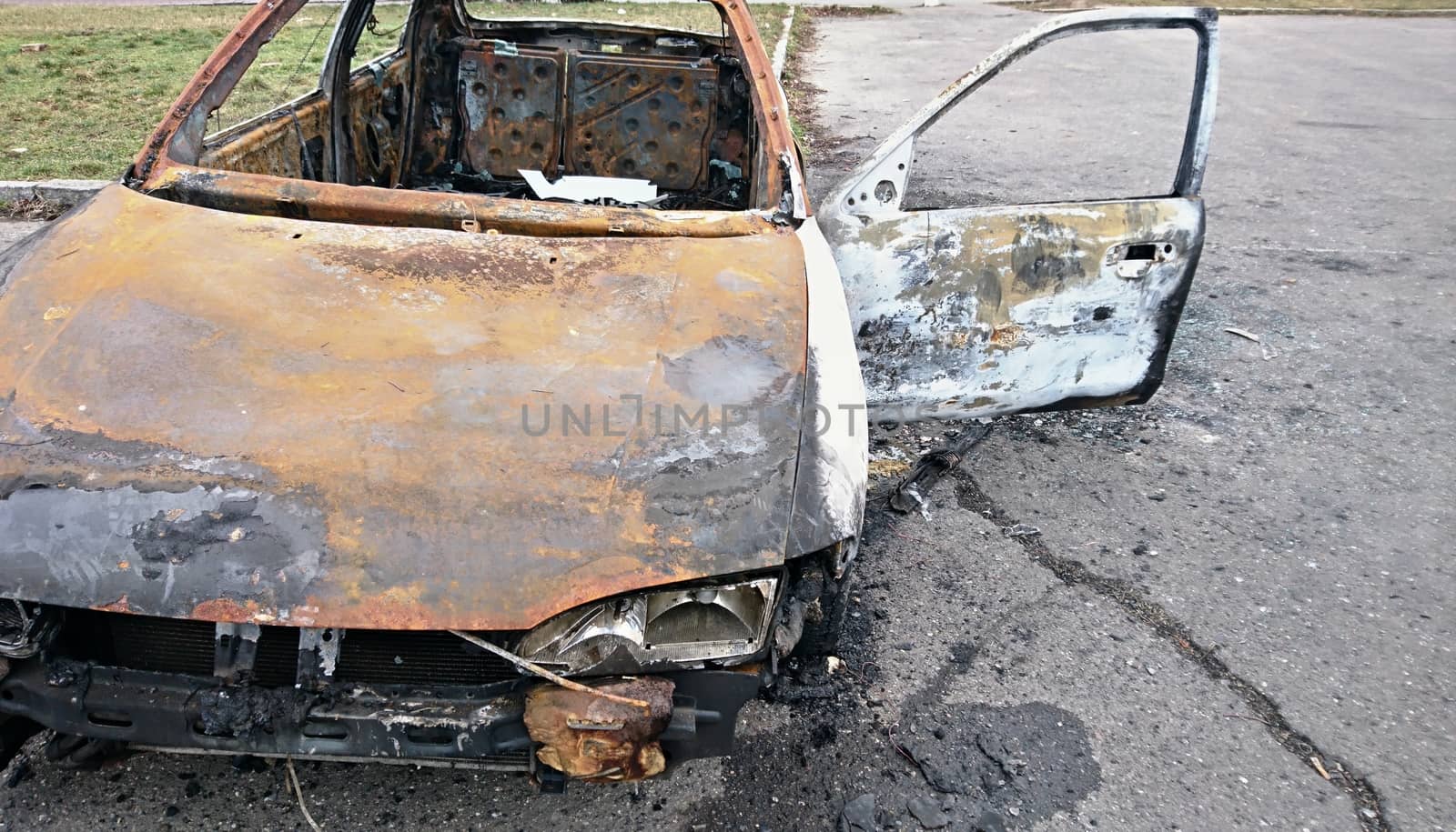 Abandoned rusty burned out car on the street.