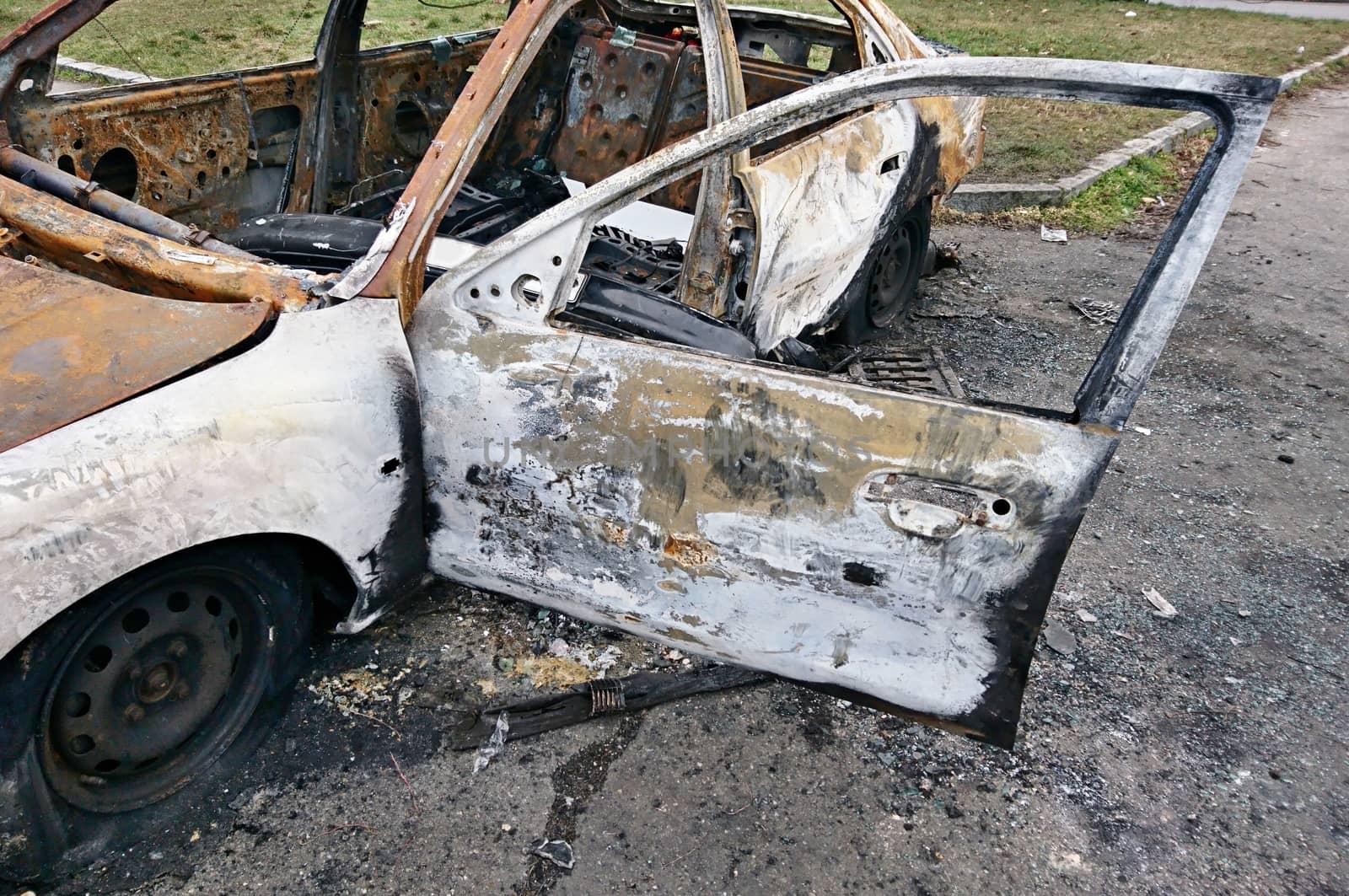 Abandoned rusty burned out car on the street.