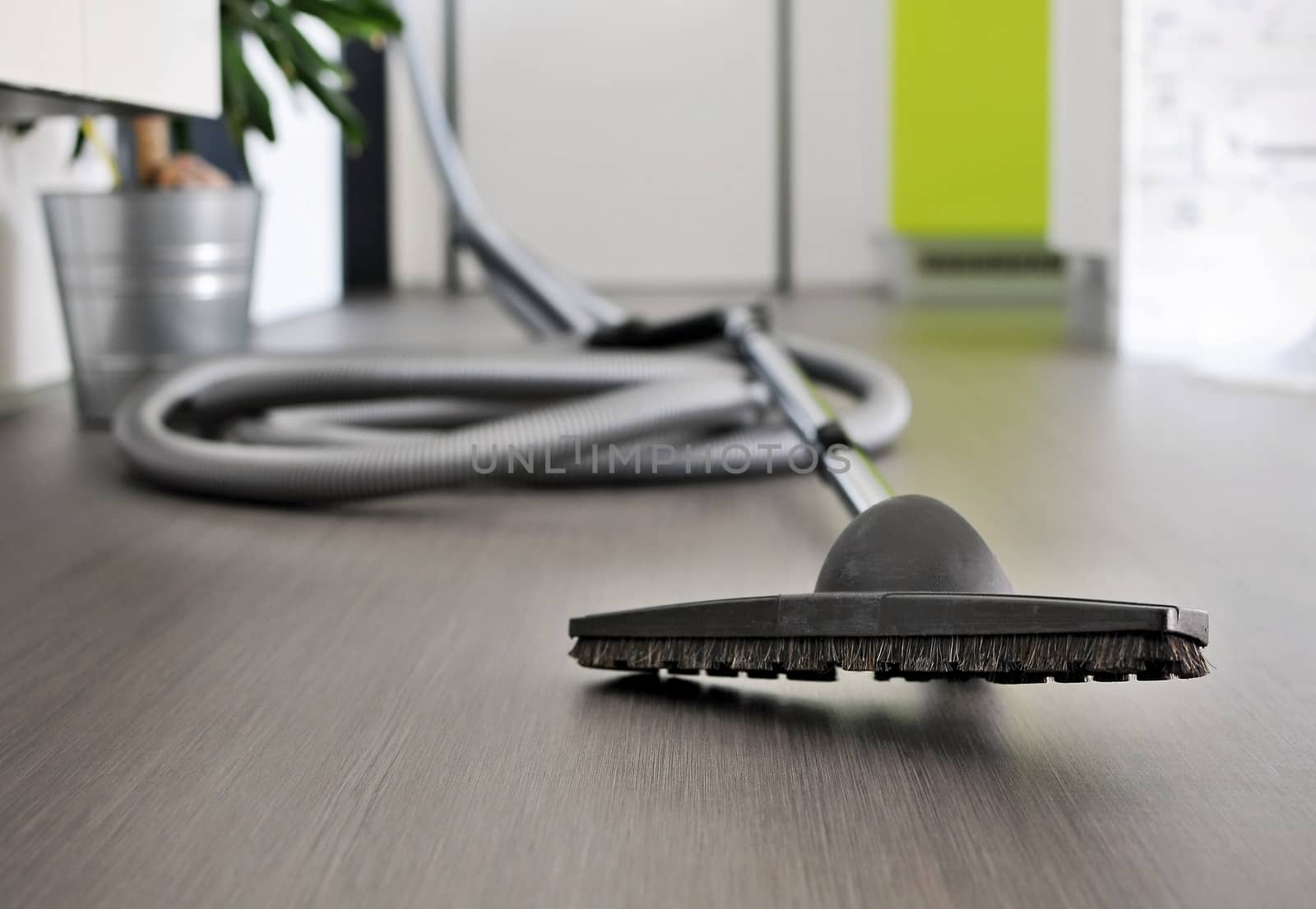 Central vacuum cleaner hose laid on the floor in the living room. Cleaning room conceptual shot, focused on foreground.