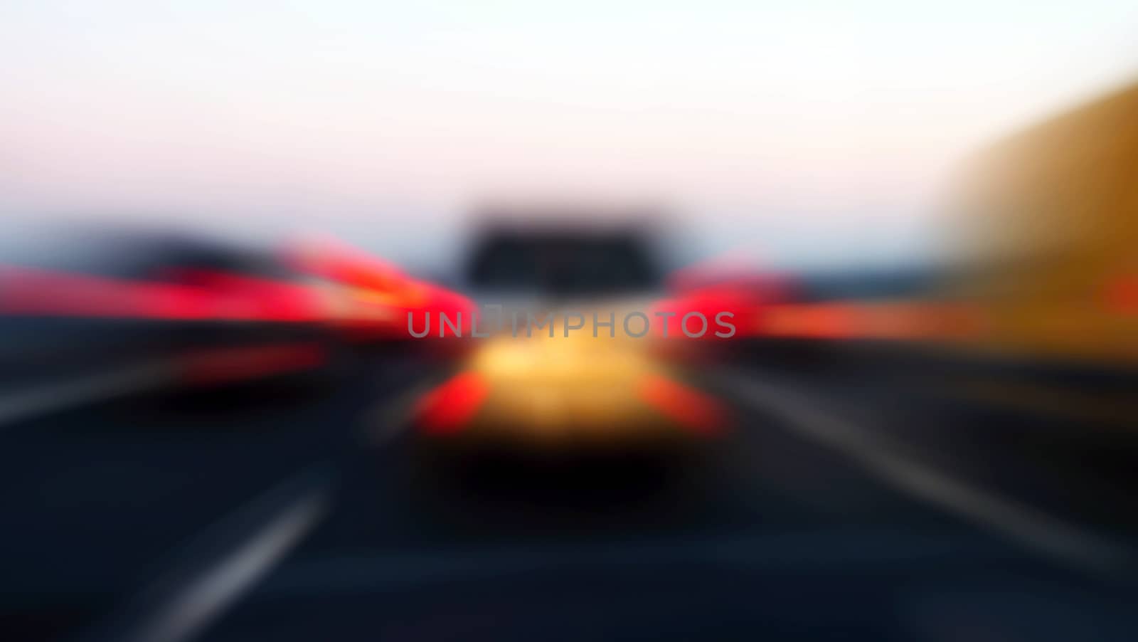 Zoom blur of rear lights of cars in motion on highway.