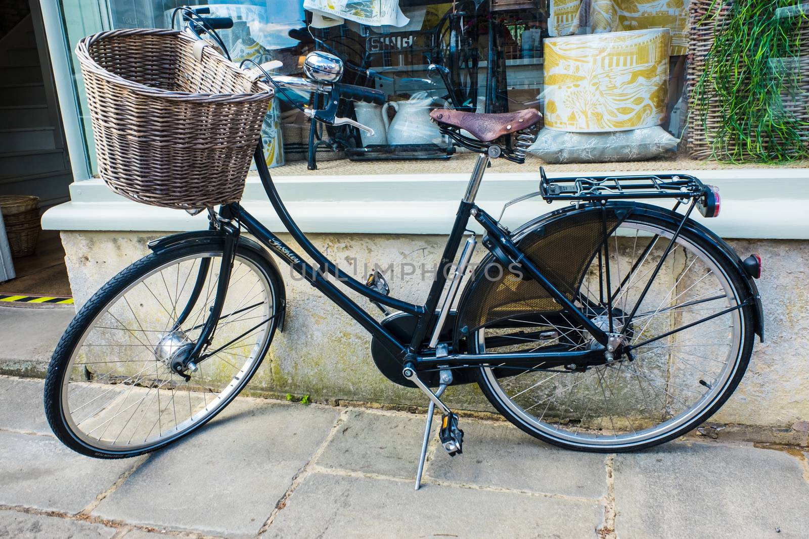 Old bicycle leaning against a shop wall by paddythegolfer