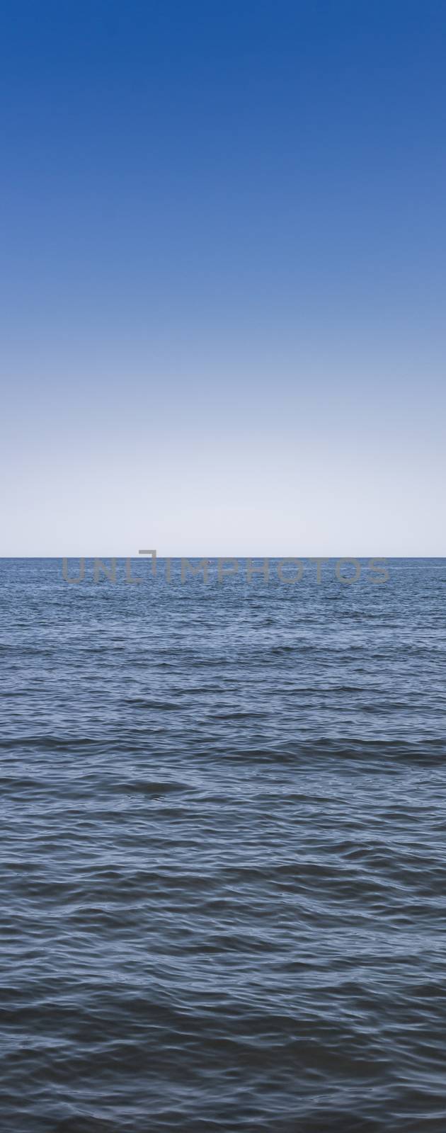 Front view of the sea with blue sky in the background.