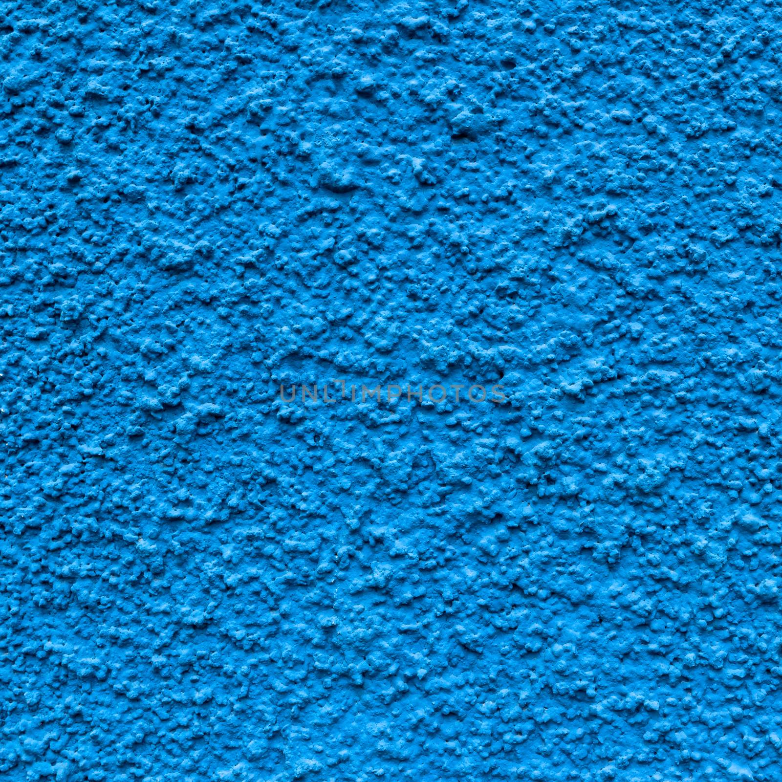 Front view of a wall decorated with blue plaster, coarse