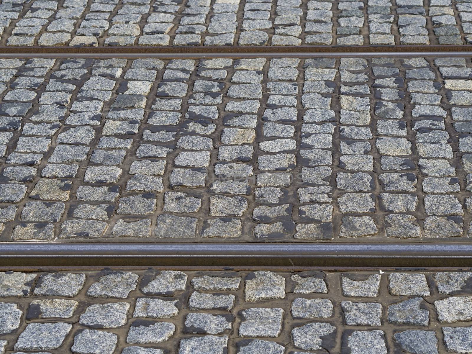 rusty tram rail line track with gray cobble stone in prague pavement