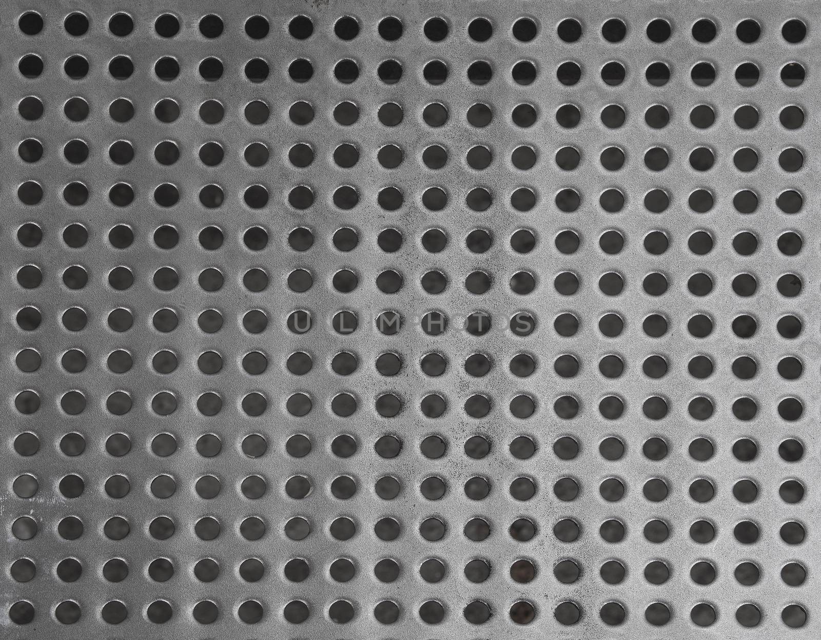 iron stainless steel grating with small regular circle shaped holes black and white geometric background