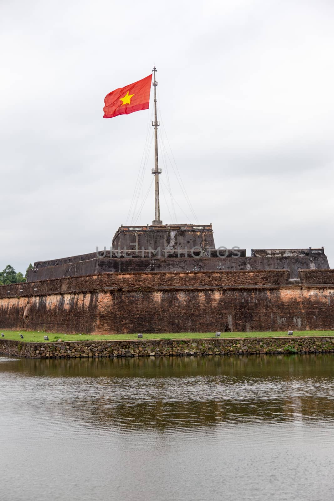 Hue, ancient capital of Vietnam. Ancient Citadel with gate and national flag. by kgboxford