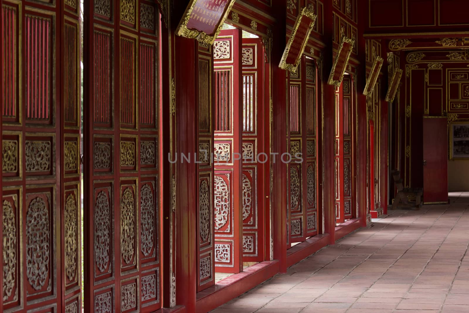 Hue, old capital of Vietnam from 1802 to 1945.. Architecture and details of buildings. Red doors gallery in Forbidden Purple City.A major attraction is its vast, 19th-century Dai Noi Citadel, surrounded by a moat and thick stone walls. It encompasses the Imperial City, with palaces and shrines. High quality photo