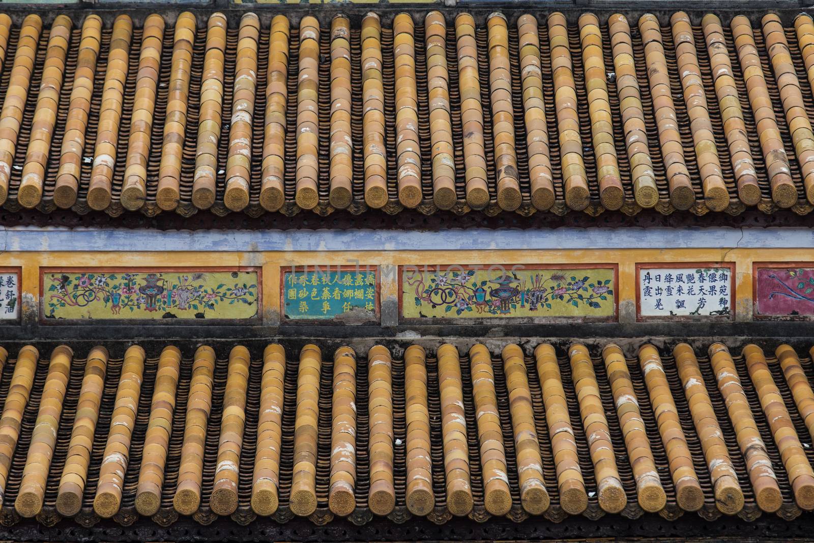 Hue, ancient capital of Vietnam. Yellow enamelled roof tiles architecture detail by kgboxford