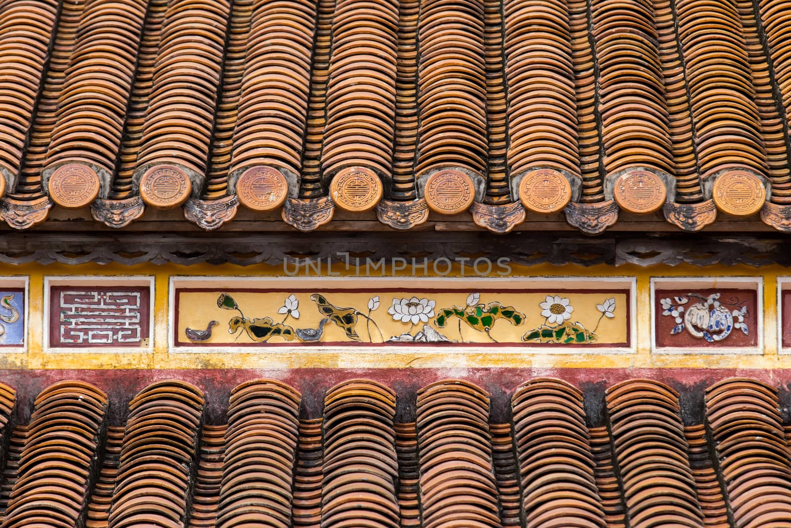 Hue, ancient capital of Vietnam. Yellow enamelled roof tiles architecture detail by kgboxford