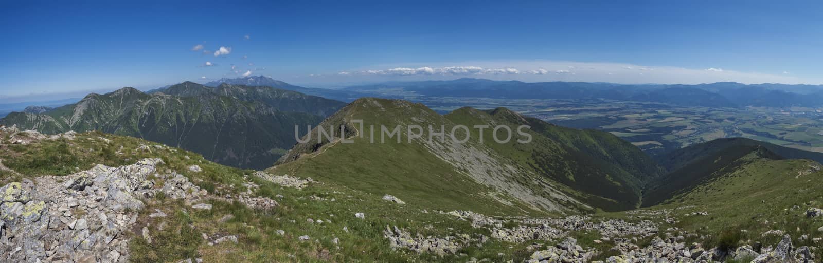 Panoramic view from Baranec peak on Western Tatra mountains Rohace, high tatras and low tatras panorama. Sharp green mountain peaks with hiking trail on ridge. Summer, blue sky white clouds