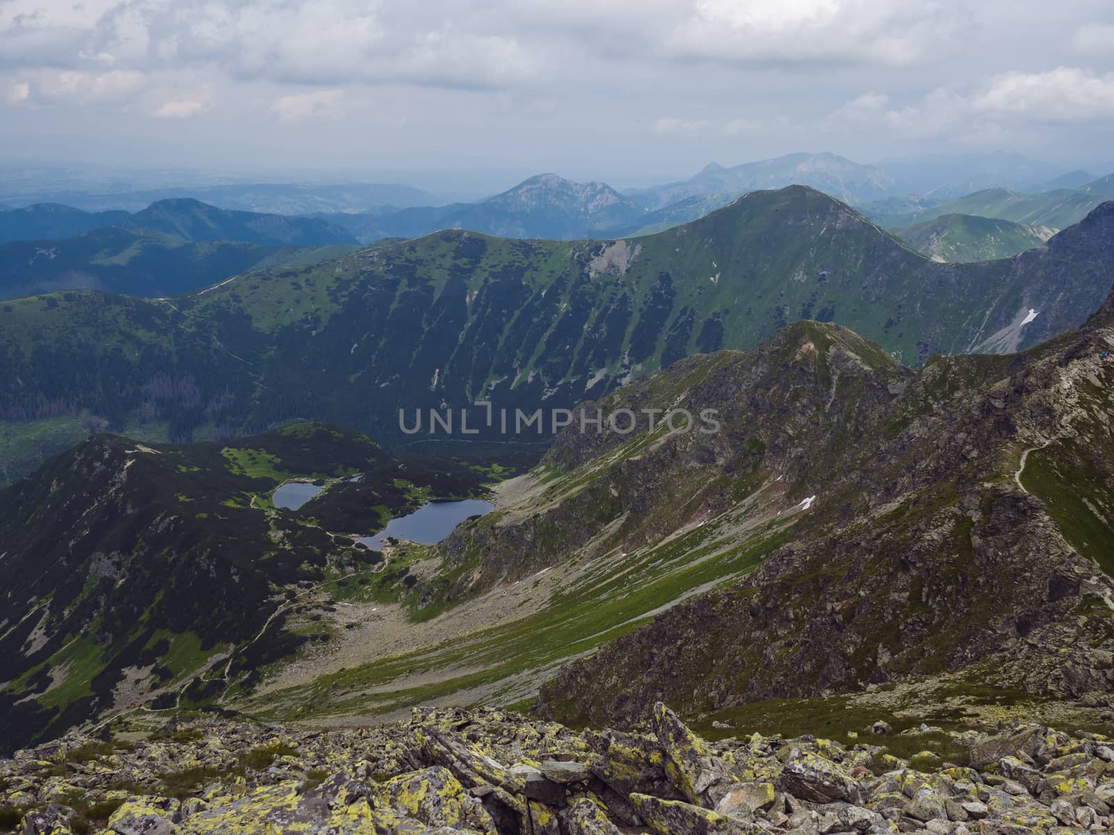 View from Banikov peak on Western Tatra mountains or Rohace panorama. Sharp green mountains - ostry rohac, placlive and volovec with hiking trail on ridge. Slovakia. Summer blue sky white clouds.