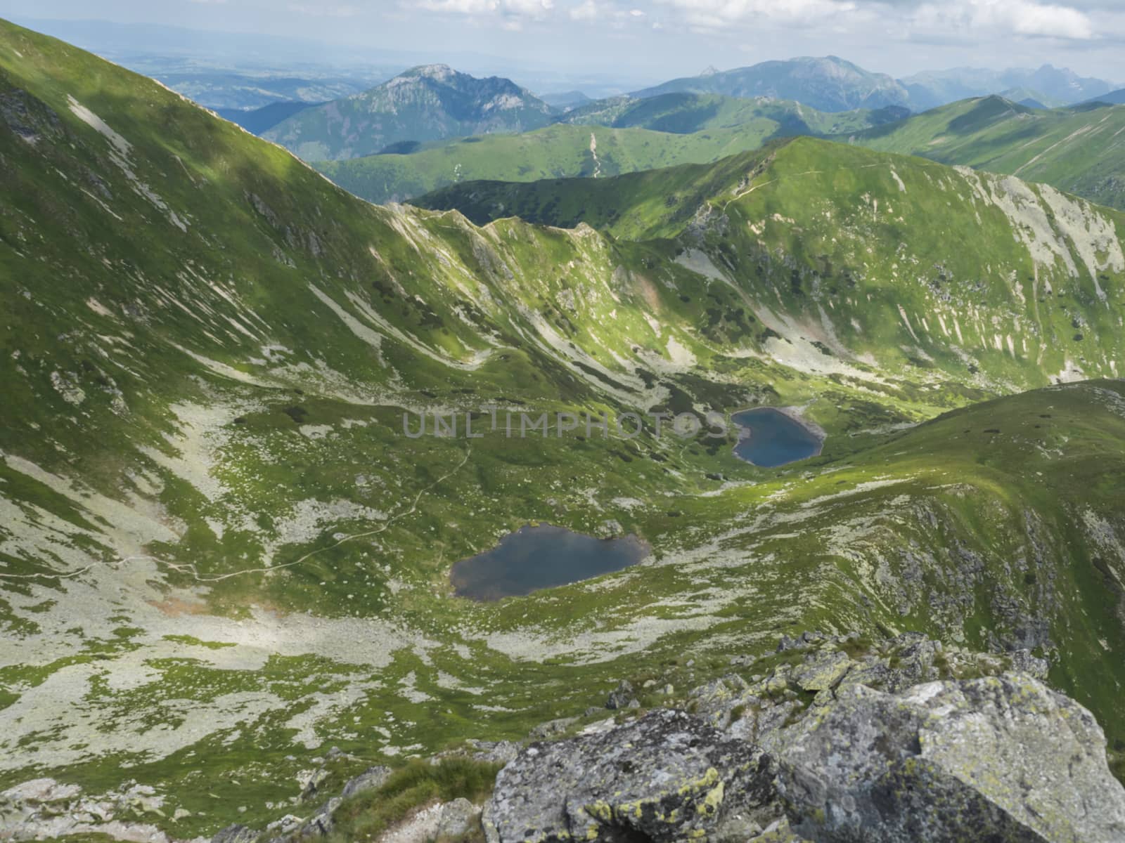 Beautiful vivid blue mountain lakes Horne and Dolne Jamnicke pleso with green mountain peaks view from the Jamnice sedlo saddle, Western Tatras mountains, Rohace Slovakia, summer sunny day blue sky.