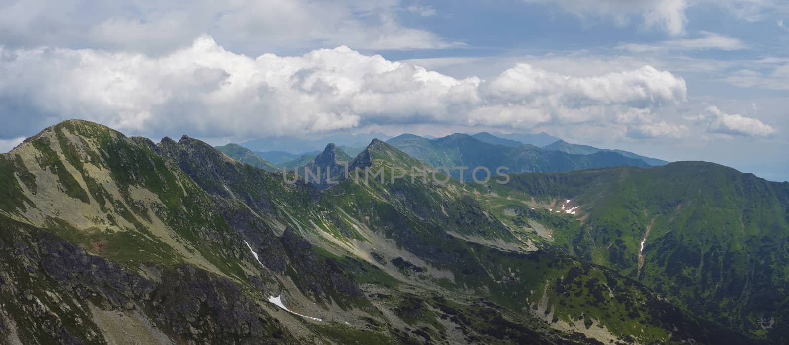 Panoramic view from Banikov peak on Western Tatra mountains or Rohace panorama. Sharp green mountains - ostry rohac, placlive and volovec with hiking trail on ridge. Slovakia. Summer blue sky white clouds.