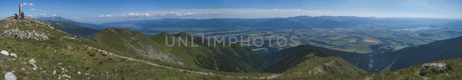 Panoramic view from Baranec peak on Western Tatra mountains Rohace, high tatras and low tatras panorama. Sharp green mountain peaks with hiking trail on ridge. Summer, blue sky white clouds