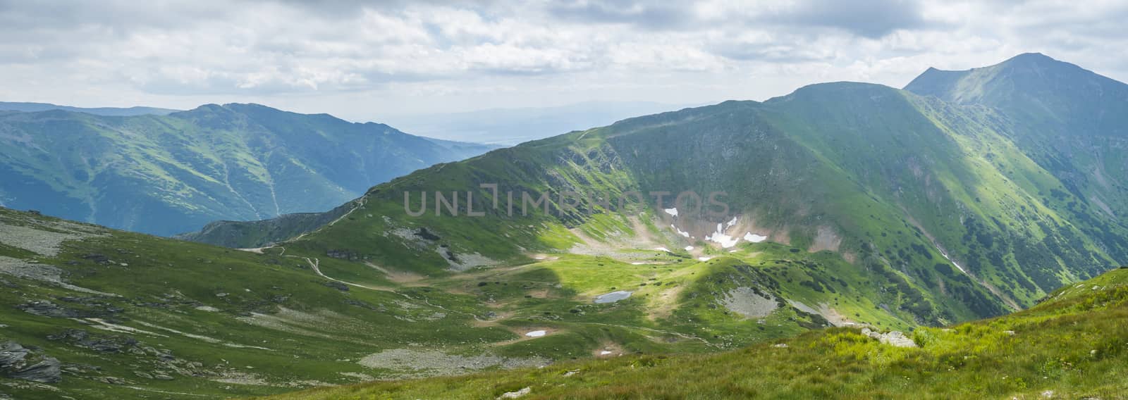 Panoramic view from Placlive peak on Western Tatra mountains or Rohace panorama. Sharp green mountains and lake rohacske pleso, ostry rohac, hruba kopa and volovec with hiking trail on ridge. Summer blue sky white clouds. by Henkeova