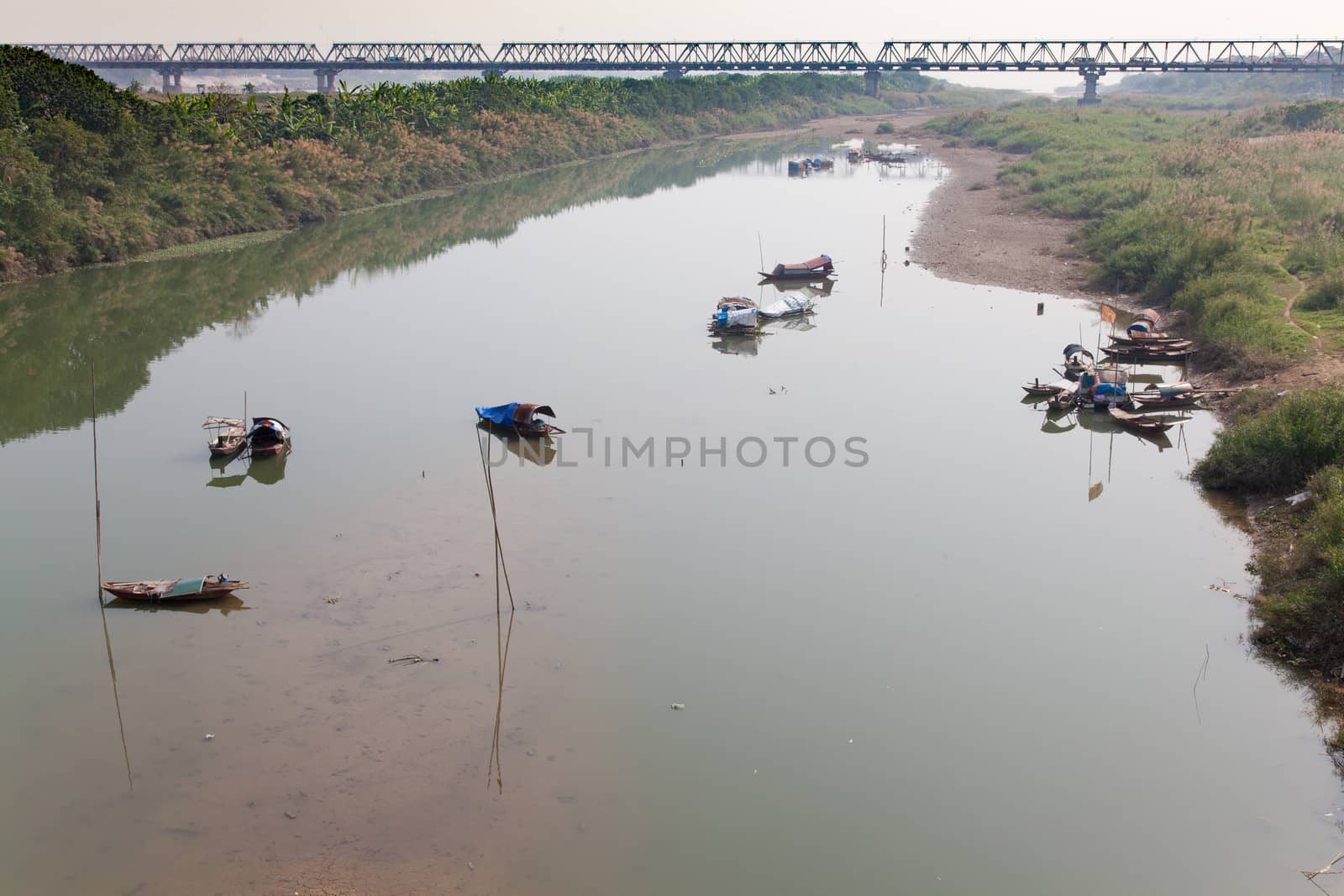 Red river, Hanoi Vietnam with house boats in foreground and Nhat Tan road bridge in the background. High quality photo