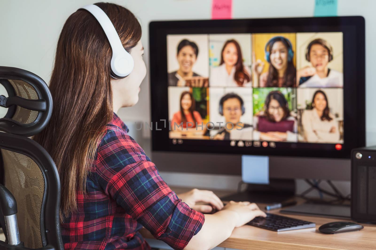 Rear view of Asian woman working and online meeting via video conference with colleague and team building when Covid-19 pandemic,Coronavirus outbreak,education and Social distancing,new normal concept