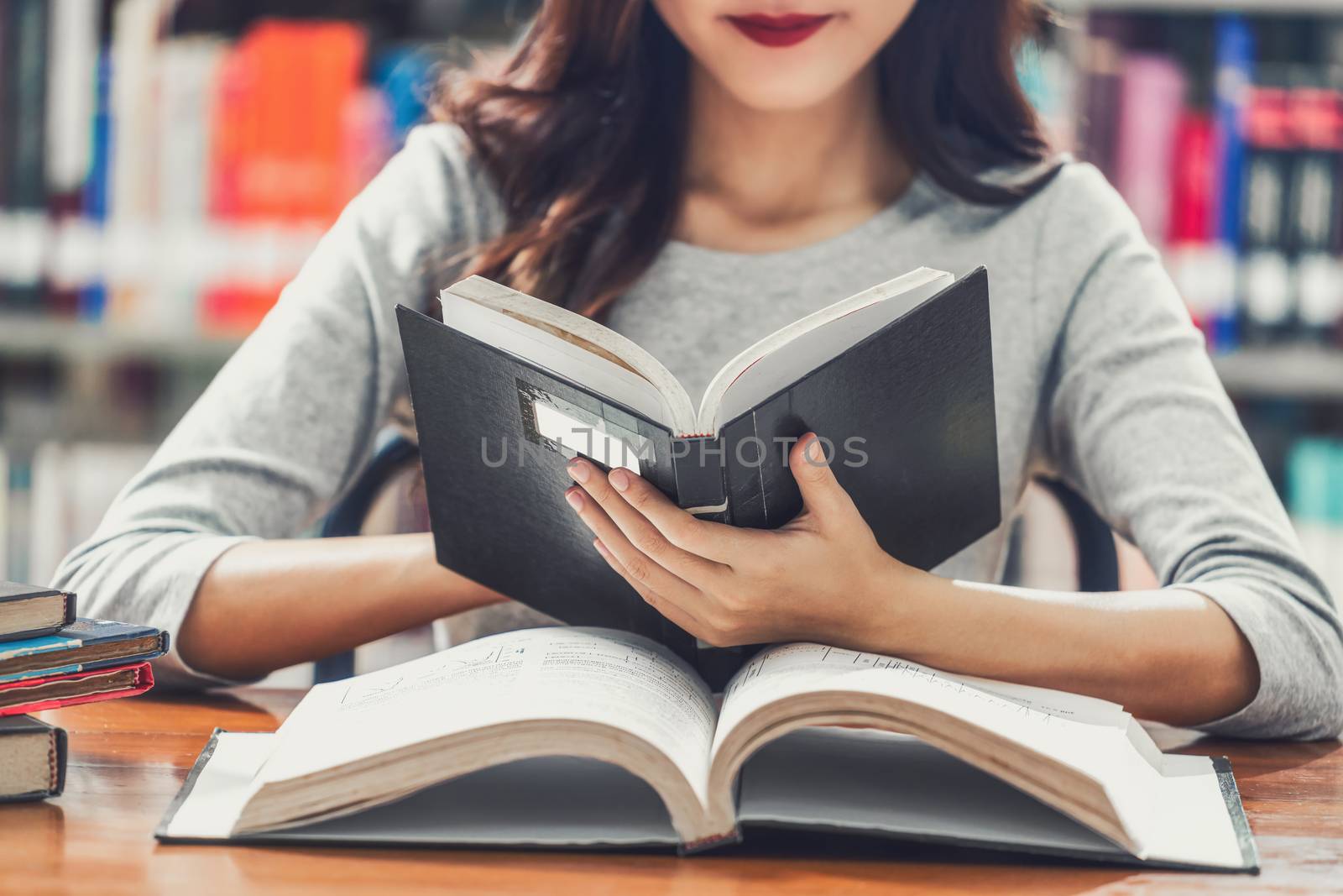 Asian young Student in casual suit reading the book on the woode by Tzido