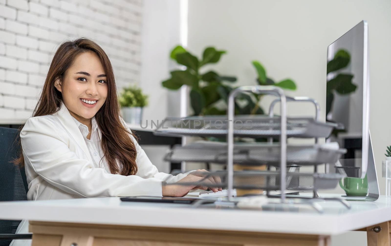 Asian business woman working and typing keyboard of technology c by Tzido