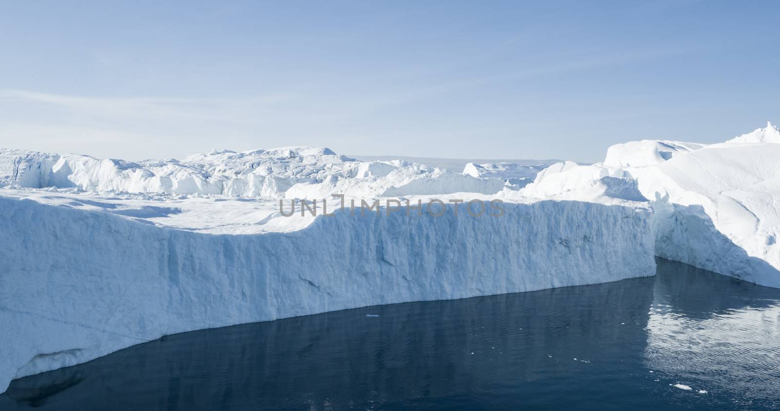 Global Warming and Climate Change concept. Icebergs from melting glacier in icefjord - Icefjord in Ilulissat, Greenland. Aerial drone photo of arctic nature ice landscape.