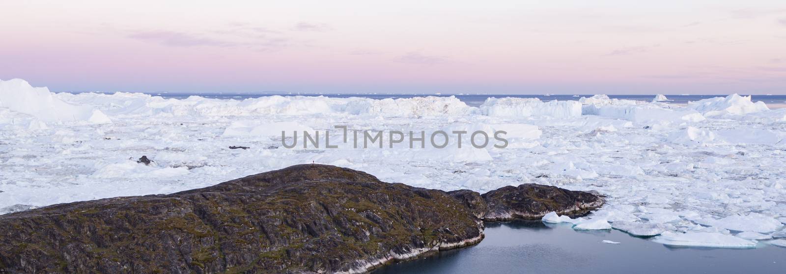 Greenland landscape nature with icebergs and ice in Greenland icefjord. Aerial drone panoramic banner photo of Ilulissat Icefjord with icebergs from Jakobshavn Glacier. Person in image for scale by Maridav