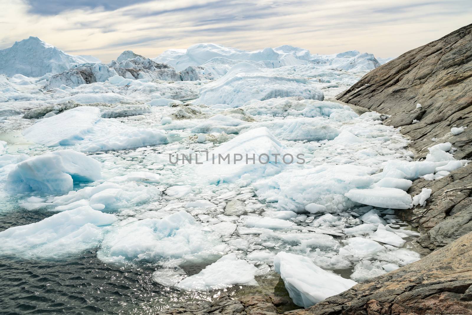 Global warming - Greenland Iceberg landscape of Ilulissat icefjord with giant icebergs. Icebergs from melting glacier. Arctic nature heavily affected by climate change.