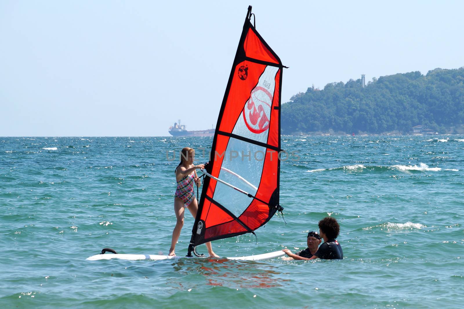 instructors teach the child to ride windsurfing by Annado