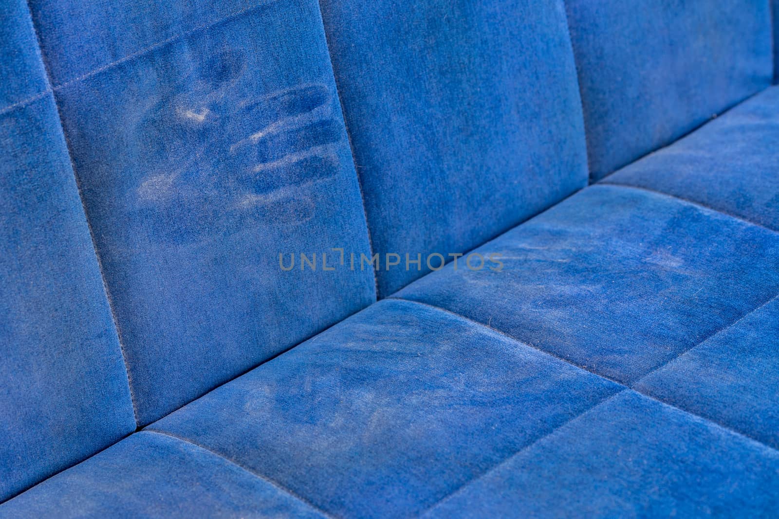 dusty blue sofa surface with palm prints closeup with selective focus.