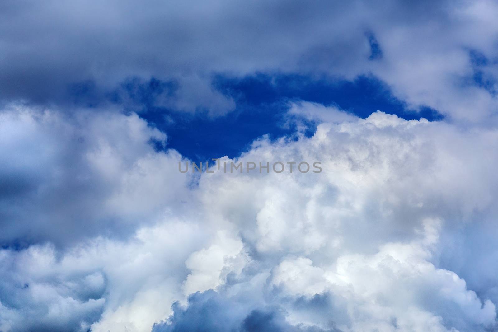 Regular spring clouds on blue sky at daylight in continental europe. Close shot wit telephoto lens and circular polarizing filter.