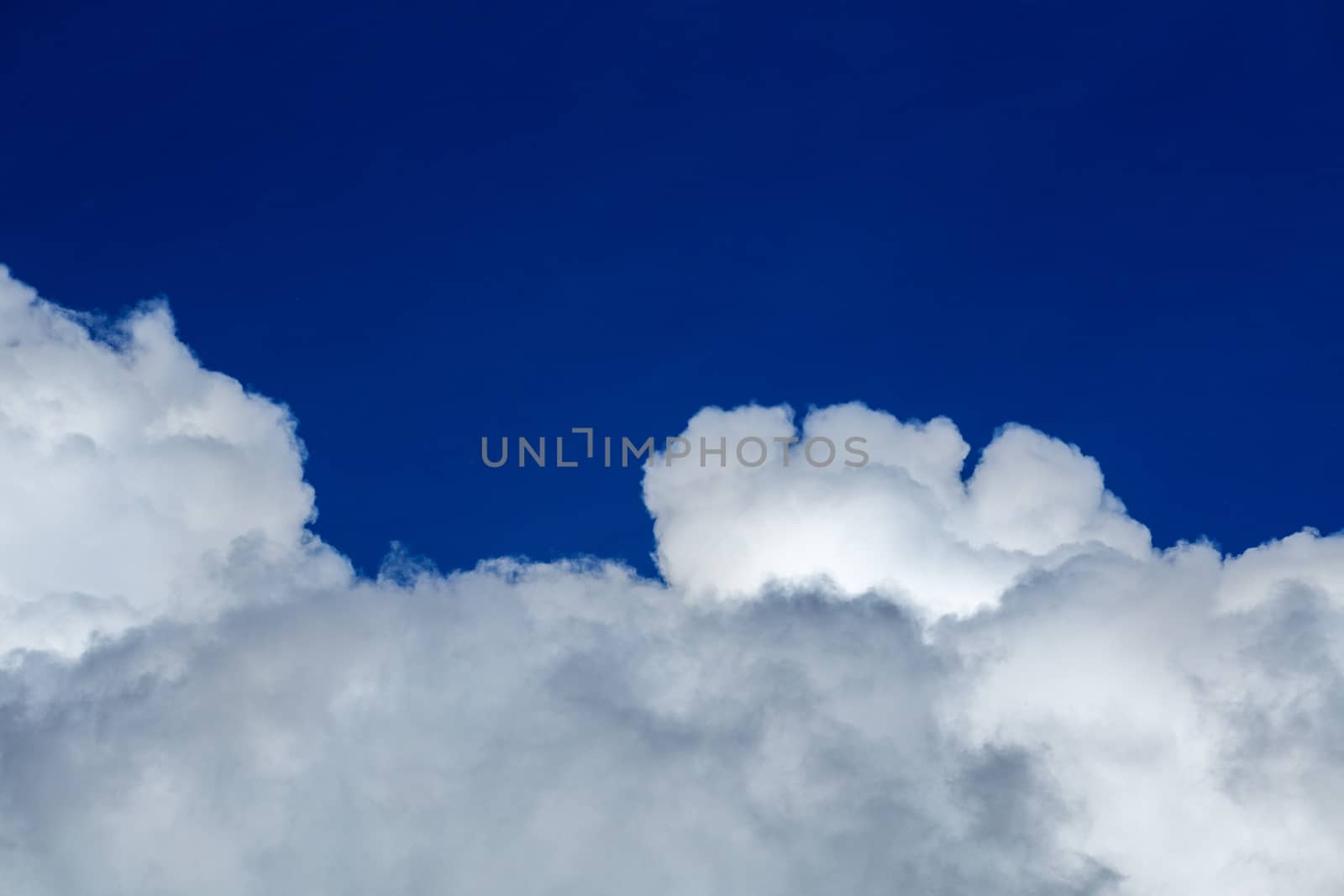 White cloud and blue sky at daylight. Close shot wit telehoto lens and polarizing filter with minimalistic composition.