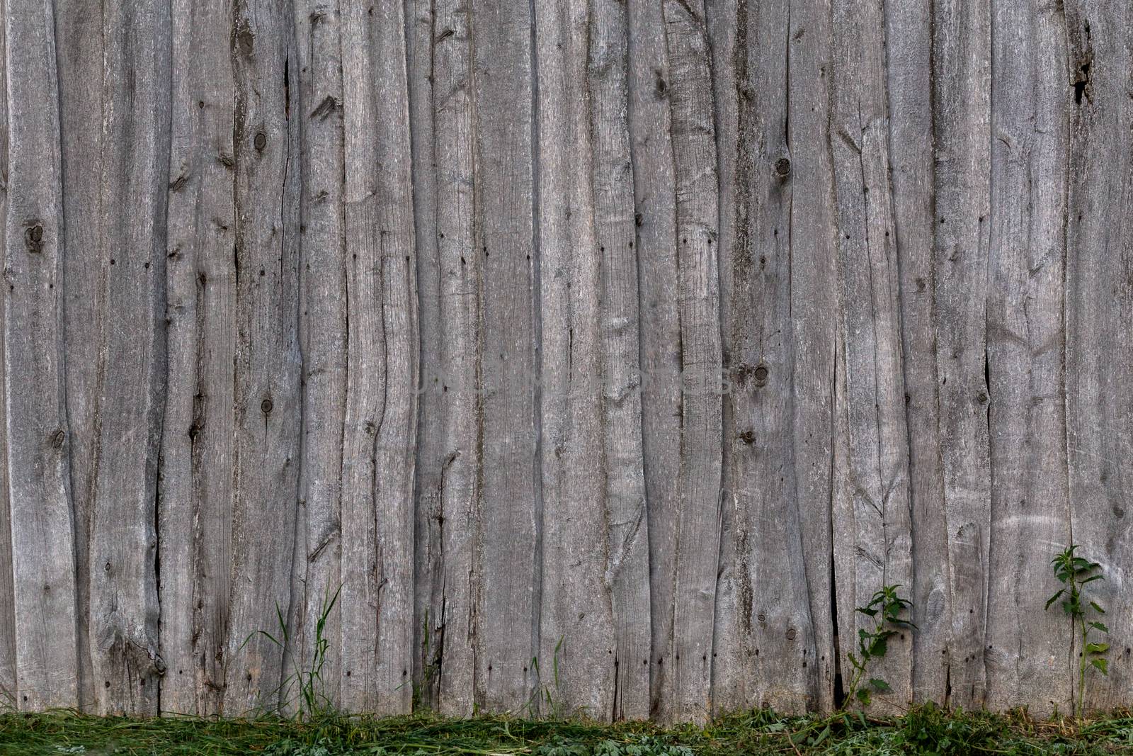 gray wooden weathered barn wall flat background template with green grass.