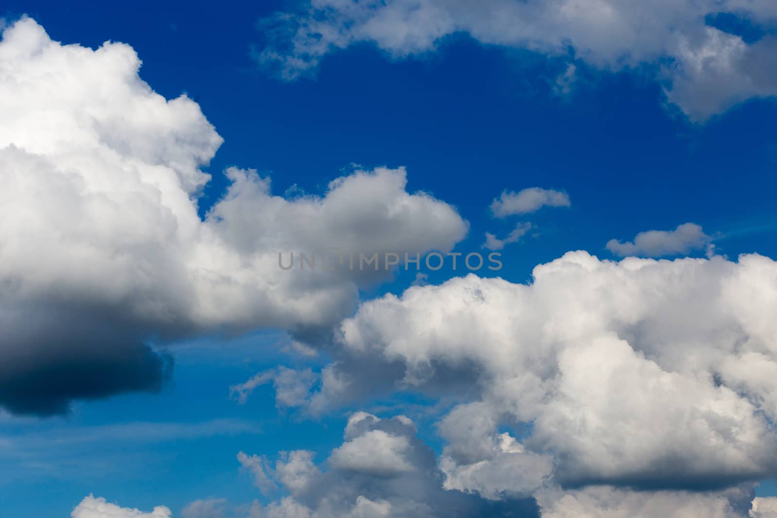 Regular spring clouds on blue sky at daylight in continental europe. Close shot wit telephoto lens and circular polarizing filter.