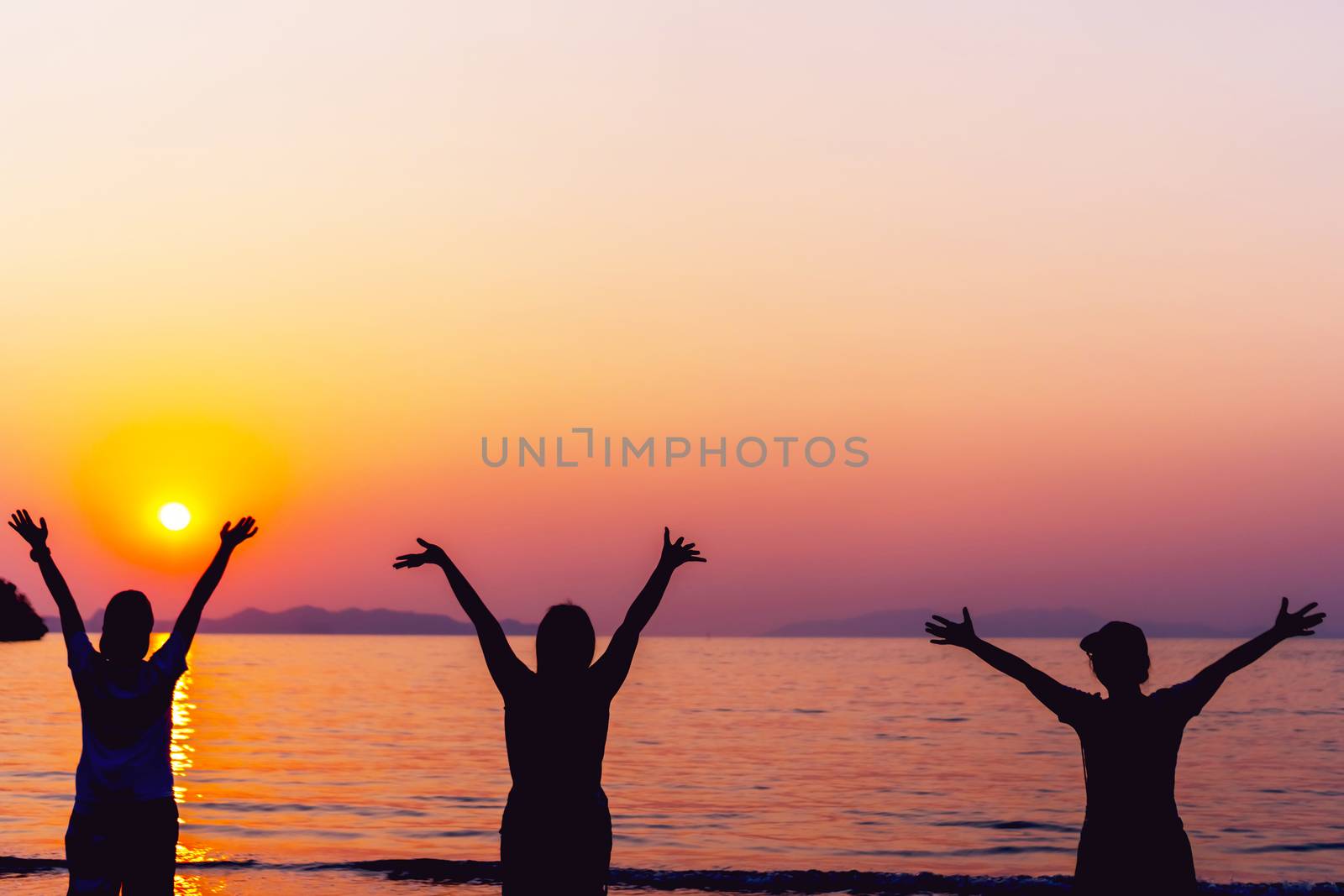 Silhouette woman rise hands up to sky freedom concept with sunset sky and summer beach season background.