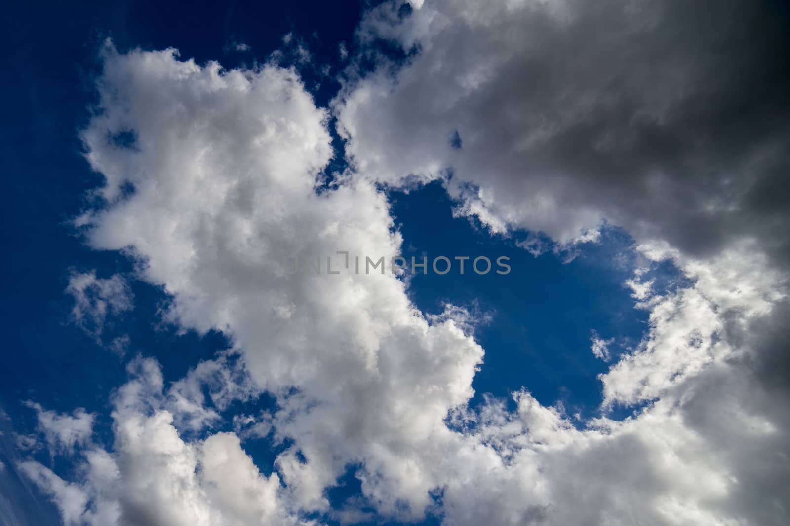 Regular spring clouds on blue sky at daylight in continental europe. Close shot with wide angle lens without any filter.