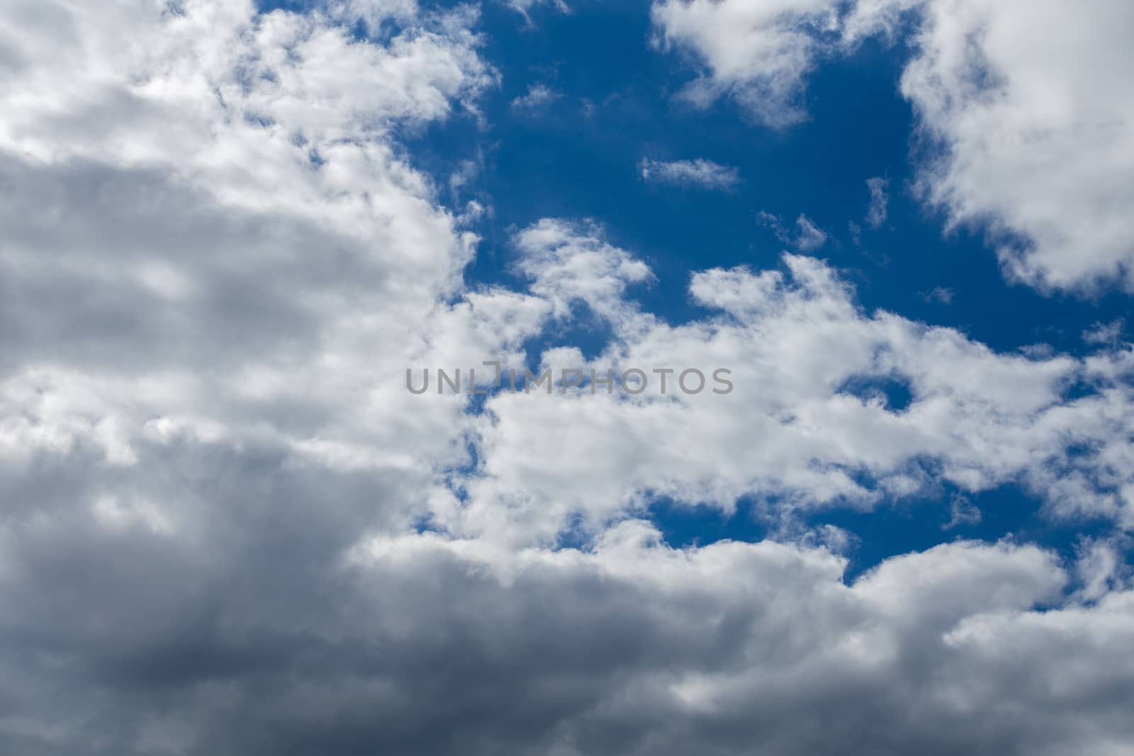 Regular spring clouds on blue sky at daylight in continental europe. Close shot wit telehoto lens and circular polarizing filter.