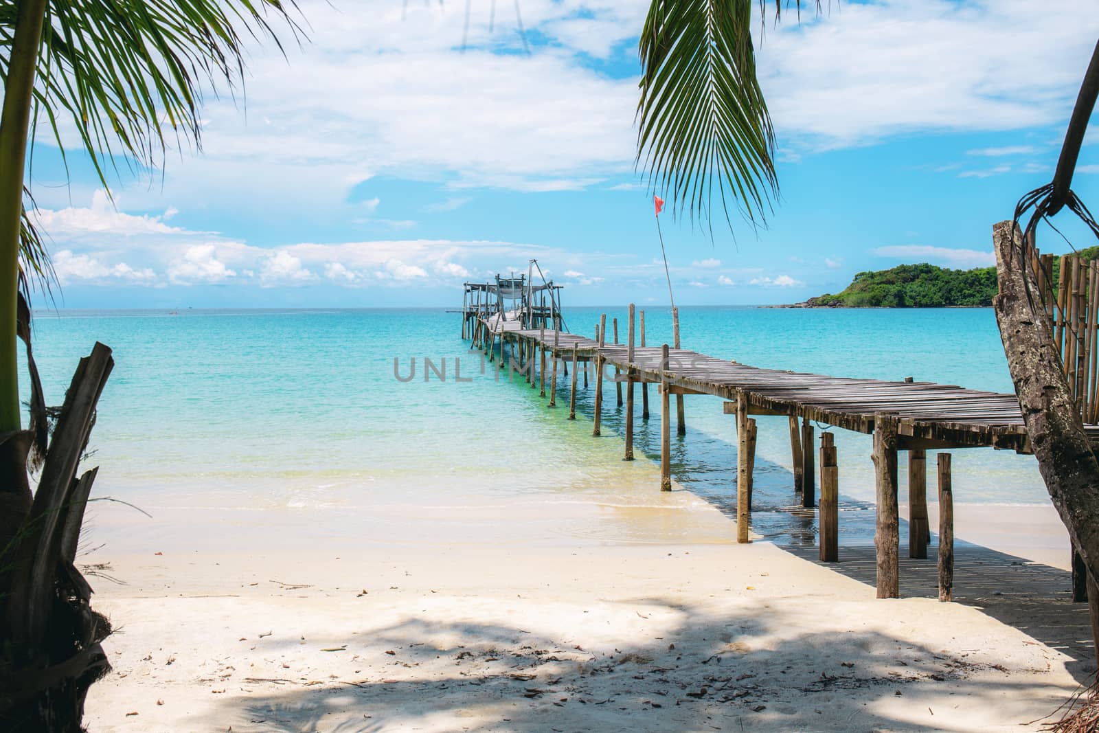 Wooden bridge on beach at the sea with blue sky.