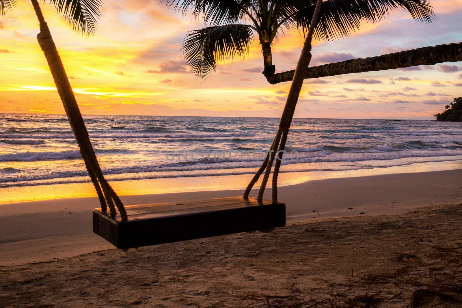 Swing on beach at sea with sunset in the summer.