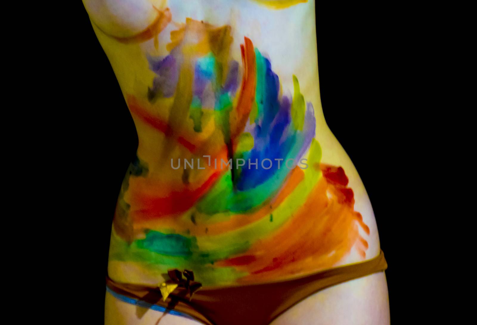 Body art. Drawing on the body. Beautiful girl with painted body watercolors. A white young girl painted the body with paint.