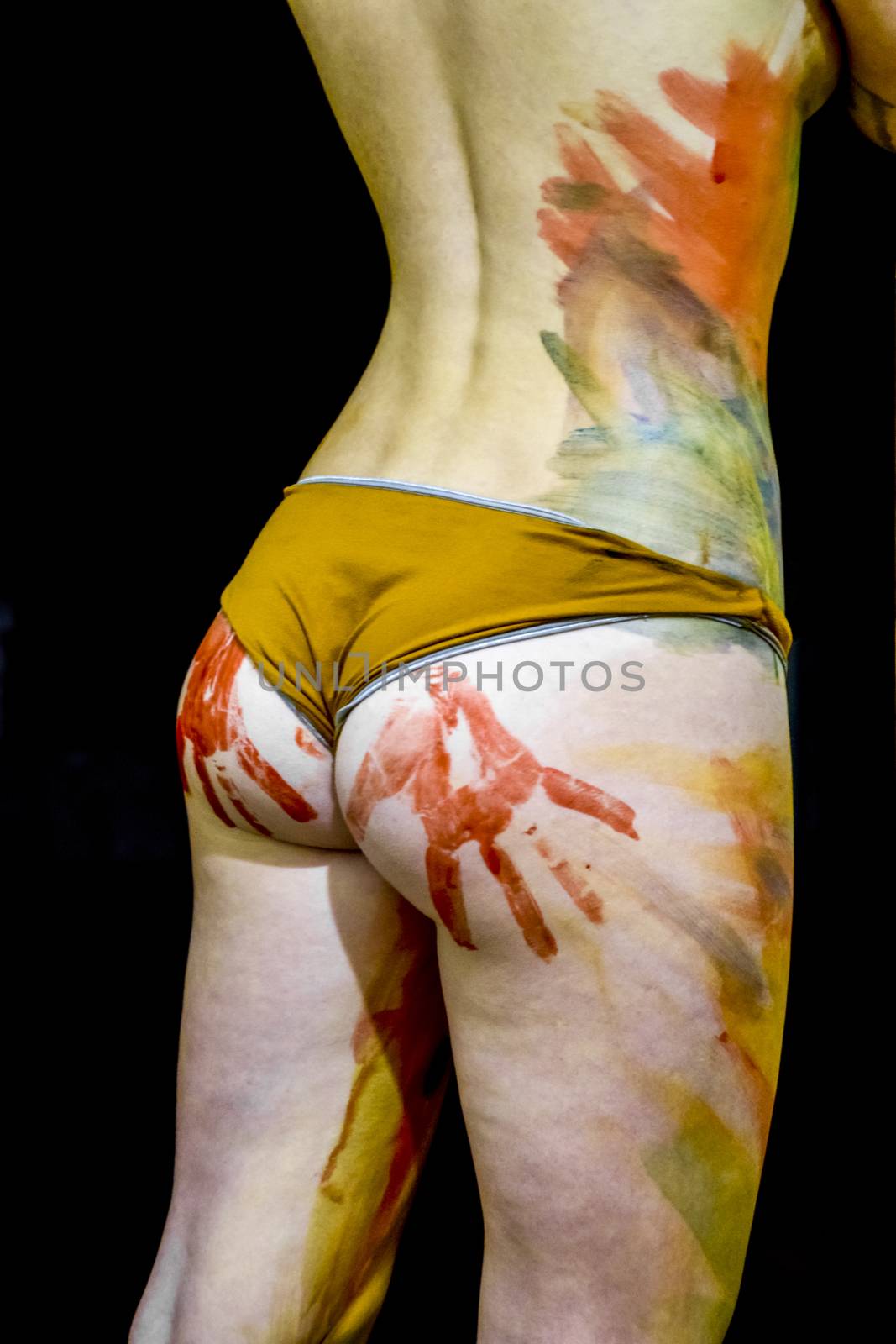 Girl with traces of the palms on the buttocks. Paint on the ass. Drawing on the body. Beautiful girl with painted body watercolors. A white young girl painted the body with paint by eleonimages