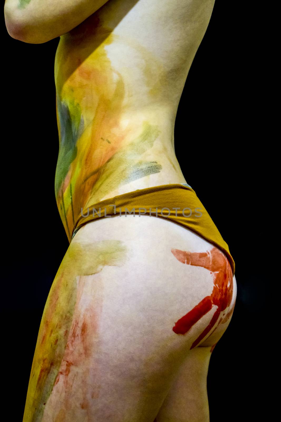 Girl with traces of the palms on the buttocks. Paint on the ass. Drawing on the body. Beautiful girl with painted body watercolors. A white young girl painted the body with paint by eleonimages